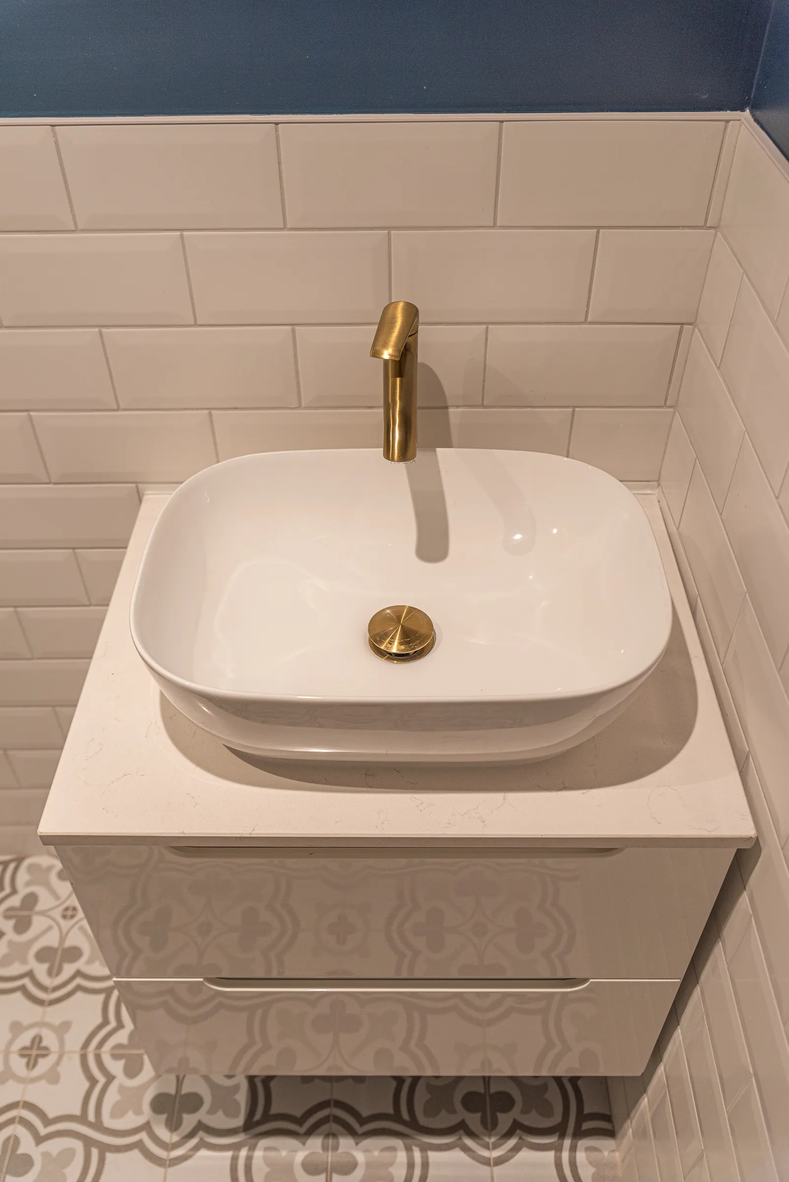 A bathroom sink with a gold faucet on it.
