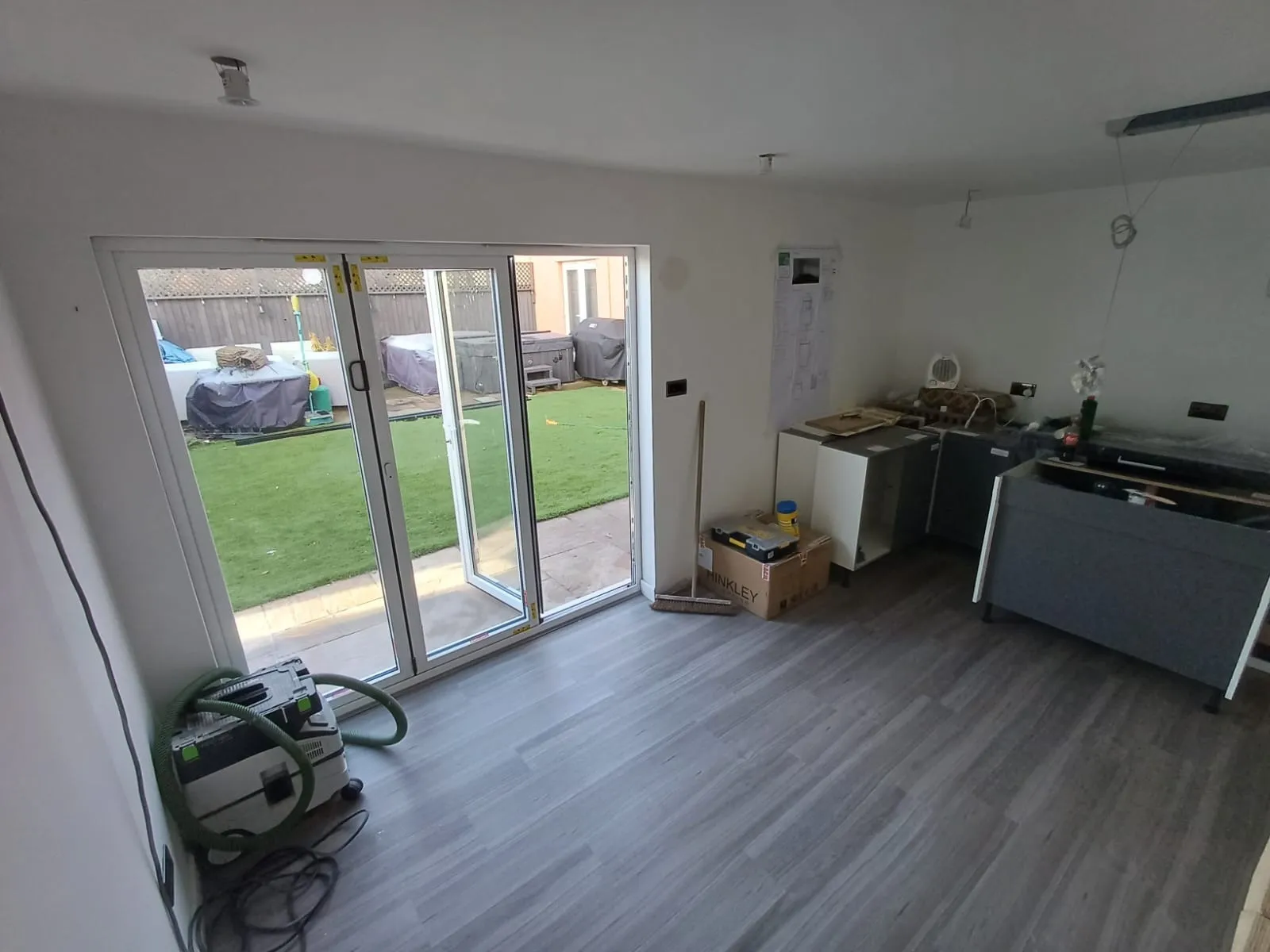 A room with a sliding glass door and a hard wood floor.