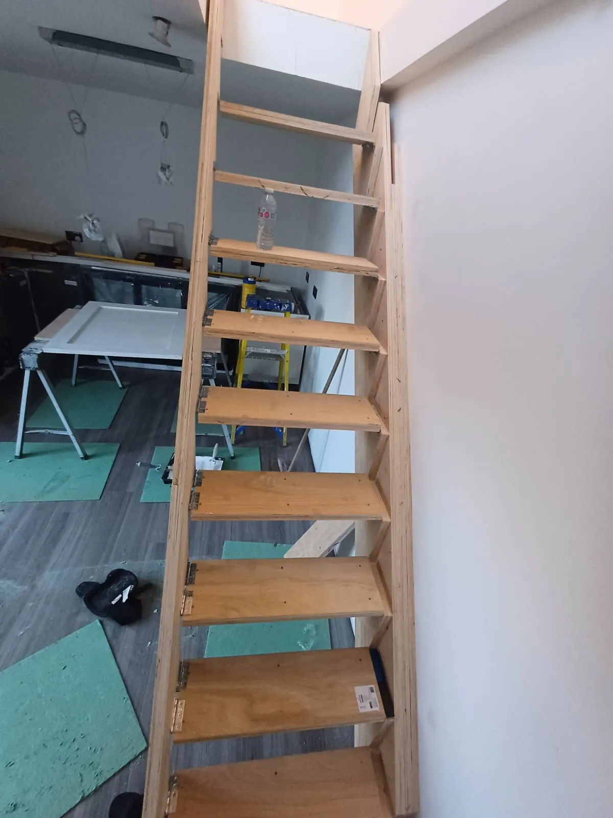 A wooden staircase in a room with hard wood flooring.