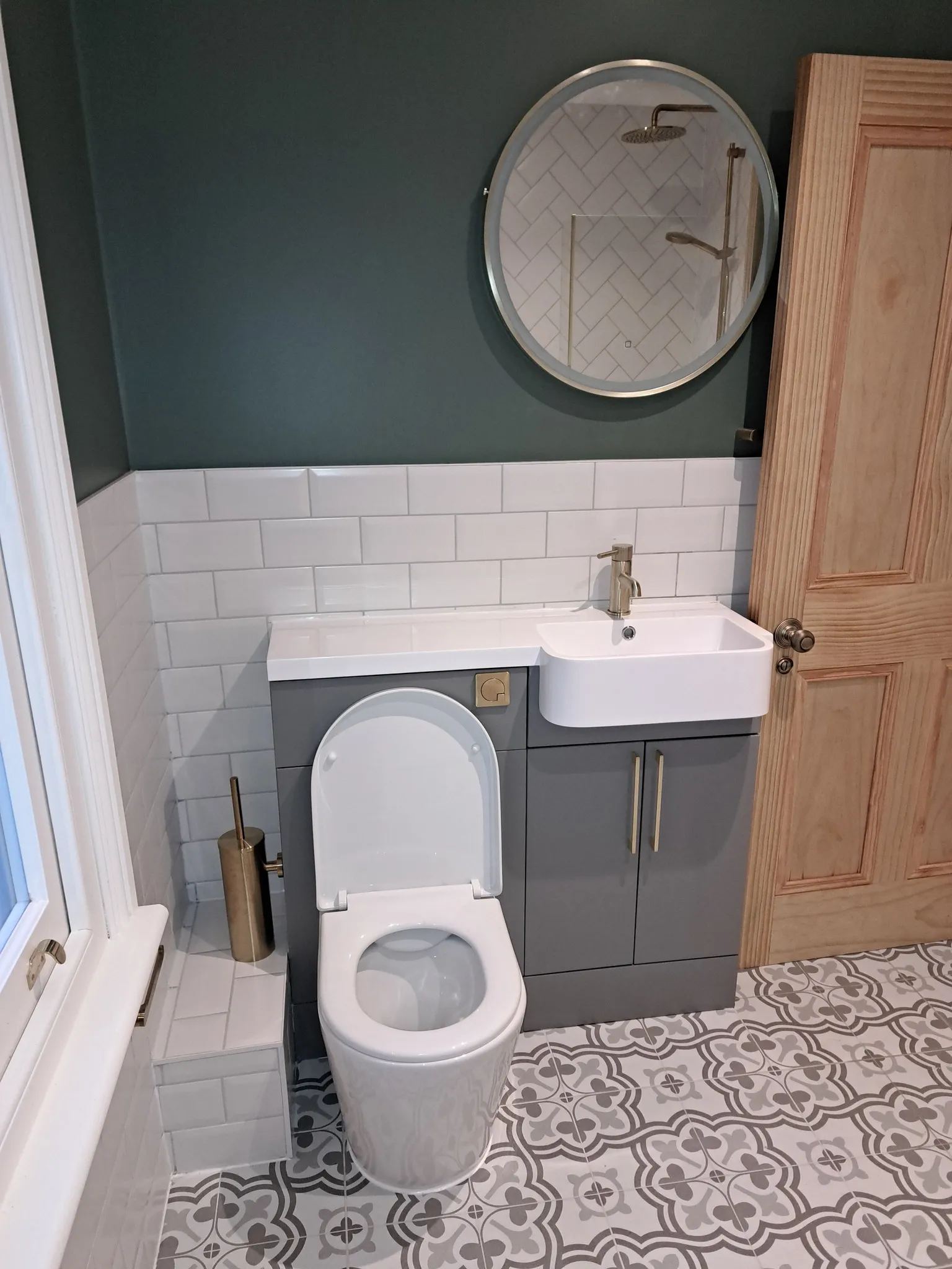 A bathroom with a toilet, sink and mirror.