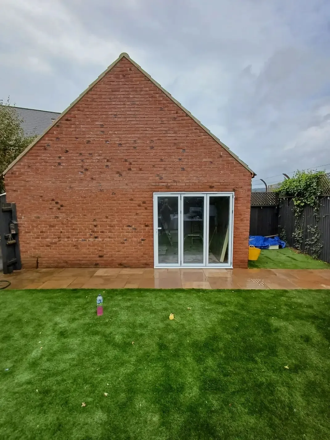 A backyard with a lawn and a brick building.