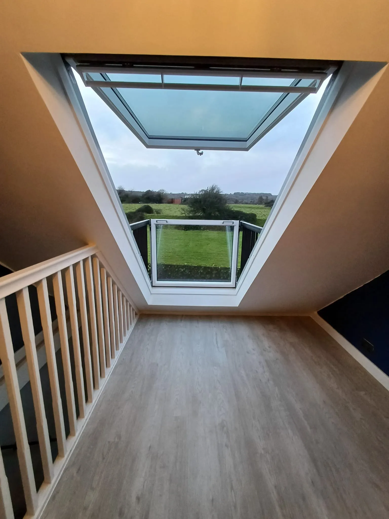 A room with a wooden floor and a skylight.